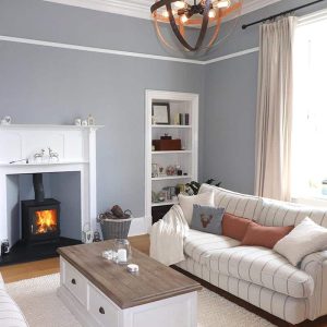 Ivar log burner from Dunholm Improvements Modern Living Room with a roaring log burner creating a cosy family home. The new wood-burning stove is the Ivar model which is modern looking, and sits well in a traditional fire surround.